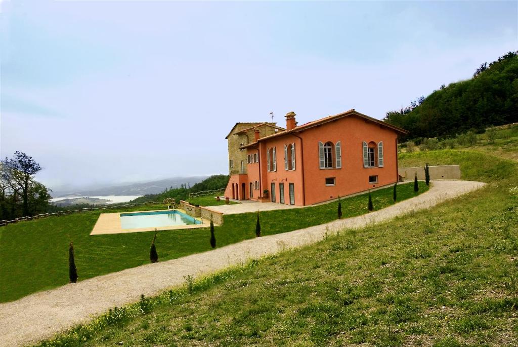 une maison sur une colline avec une piscine dans l'établissement Agriturismo Rimaggiori relaxing country home, à Barberino di Mugello