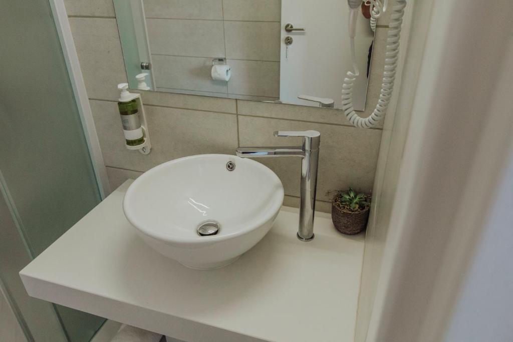 a bathroom with a white sink on a counter at River View Boutique Apts in Ayia Napa
