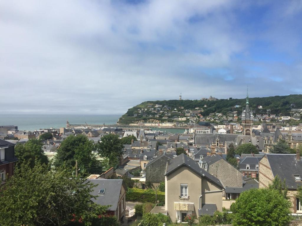 a city with houses and the ocean in the background at Les Embruns Fecampois in Fécamp