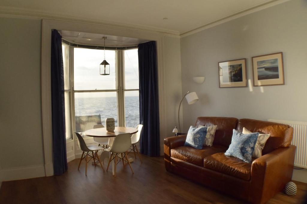 a living room with a couch and a table at Awel Mor 3 Luxury Apartment in Aberystwyth