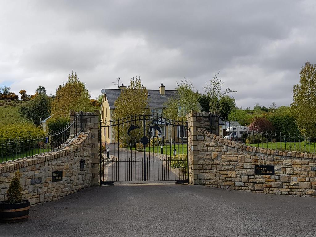 um portão para uma casa com uma parede de pedra em Sleepy Hollow B&B em Donegal