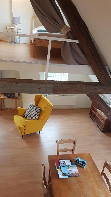 a living room with a yellow chair and a table at Homestay Stavenisse in Stavenisse
