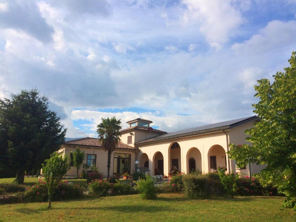 um grande edifício com uma palmeira no quintal em Villa Giulia em Avezzano