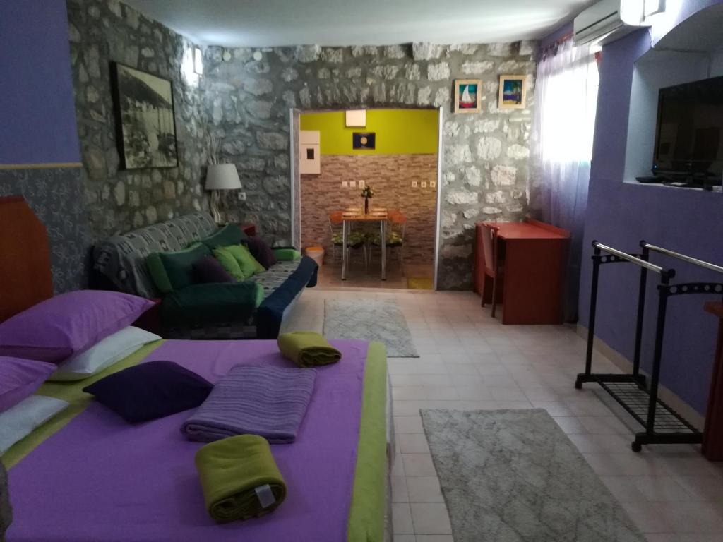 un soggiorno con letto viola e divano di Apartments Hana a Makarska