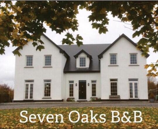 a white house with the words savven oaks bdb at Seven Oaks B&B in Ballyhaunis