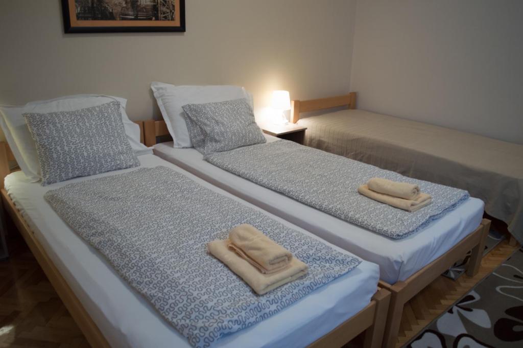 2 Betten in einem Zimmer mit Handtüchern darauf in der Unterkunft Guest House Dimitrije in Niška Banja