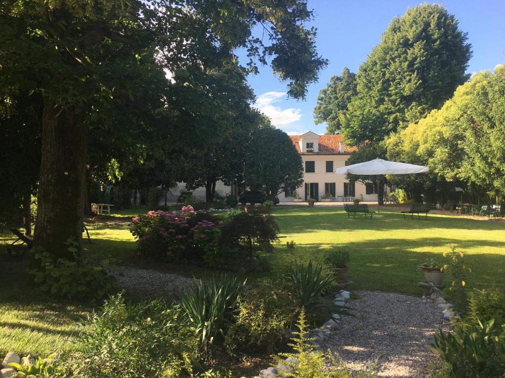 un giardino con una casa sullo sfondo di Ca' Settecento "Villa Cavazza Querini" a Pasiano di Pordenone