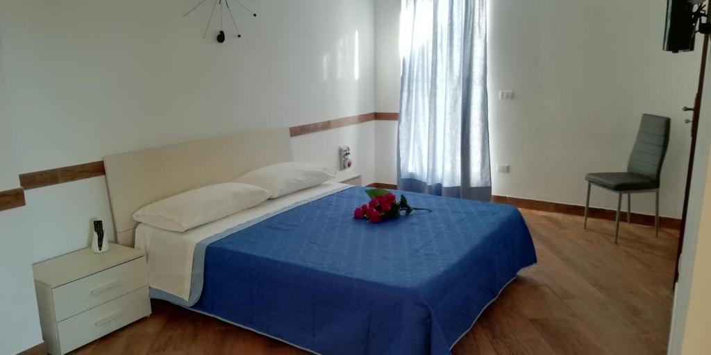 una camera da letto con un letto con una coperta blu e fiori di Sogno d'estate a Mazara del Vallo