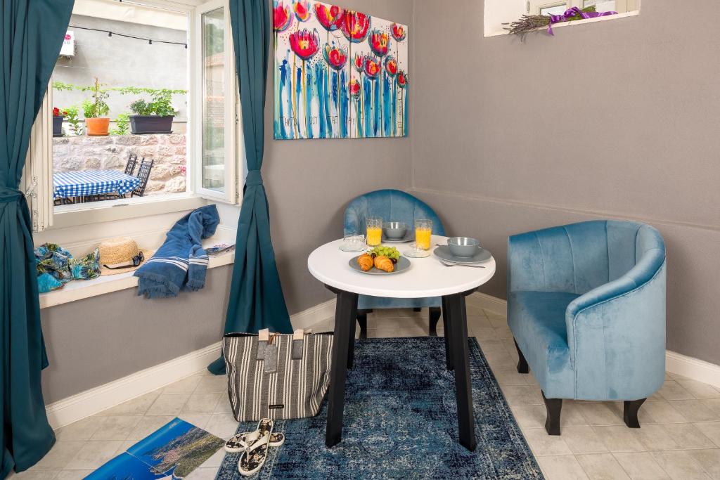 mały stolik i dwa niebieskie krzesła w pokoju w obiekcie Kampanel 10 w Hvarze