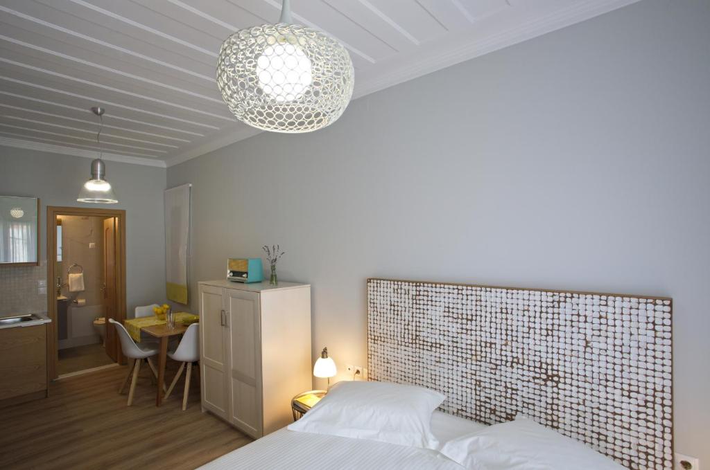 ein Schlafzimmer mit einem Bett und ein Zimmer mit einem Tisch in der Unterkunft Casa di fiori in Lefkada Town