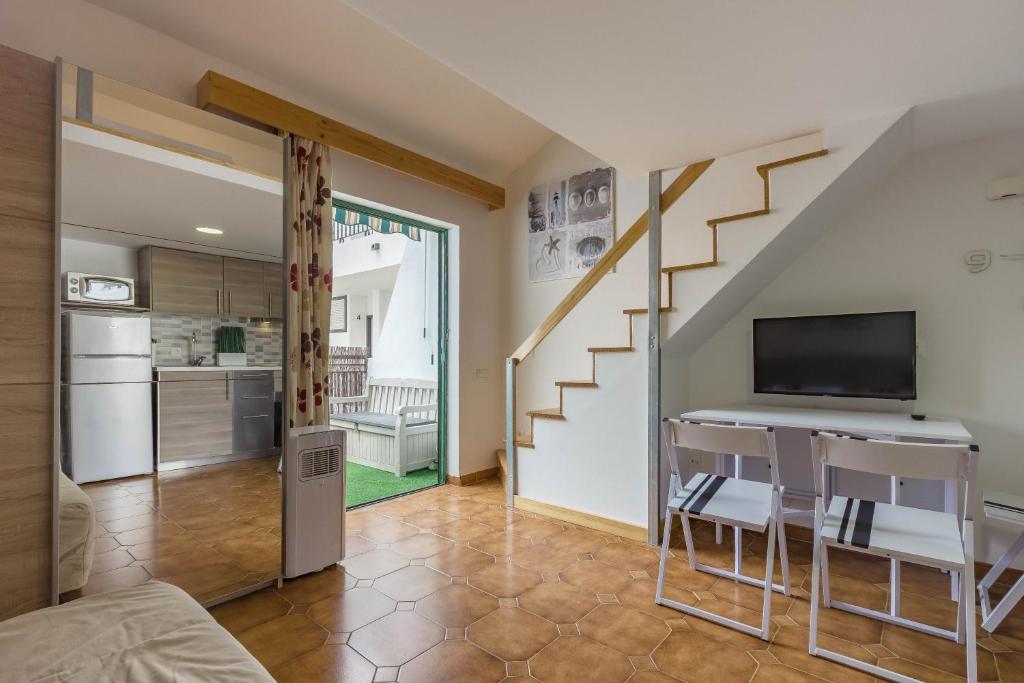 a living room with a staircase and a kitchen at AirCon Los Cristianos, Quiet zone, Chipeque in Arona