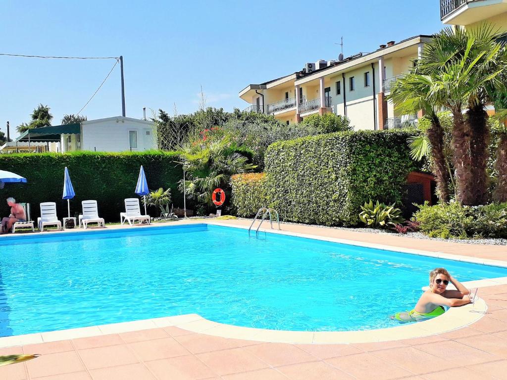 Kobieta siedzi w basenie. w obiekcie Hotel Fornaci w mieście Peschiera del Garda