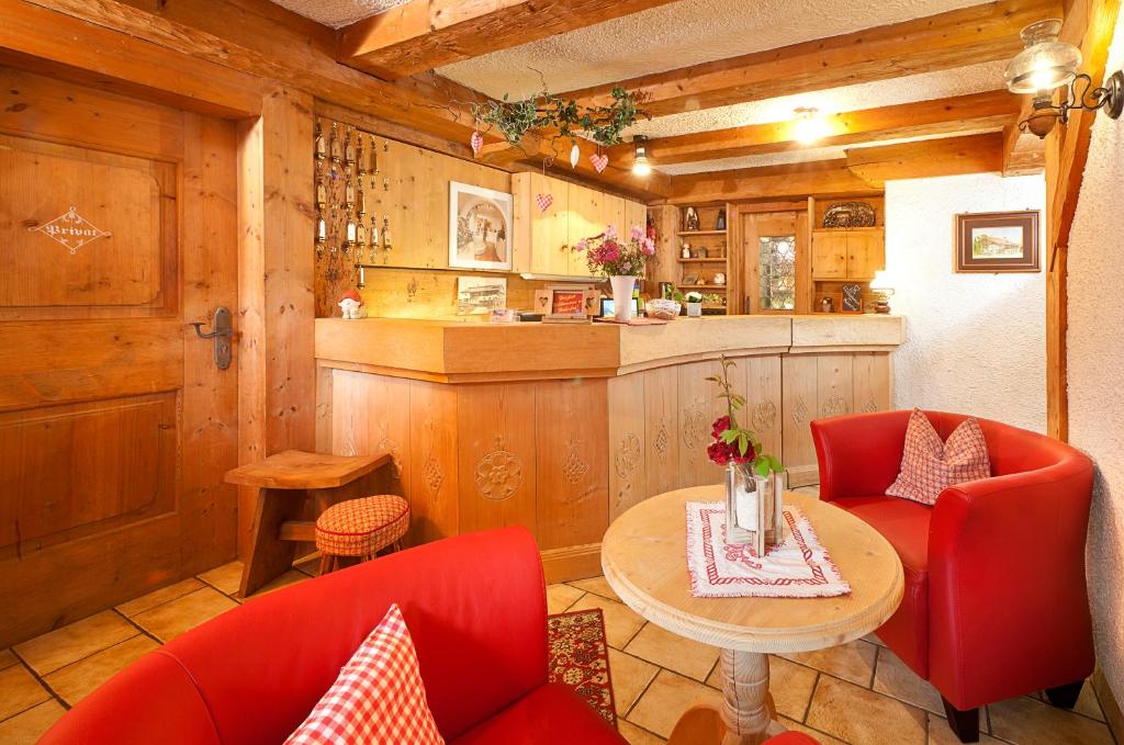 シュヴァンガウにあるランドホテル ハバーホフの赤い椅子とテーブル、カウンター付きのキッチン