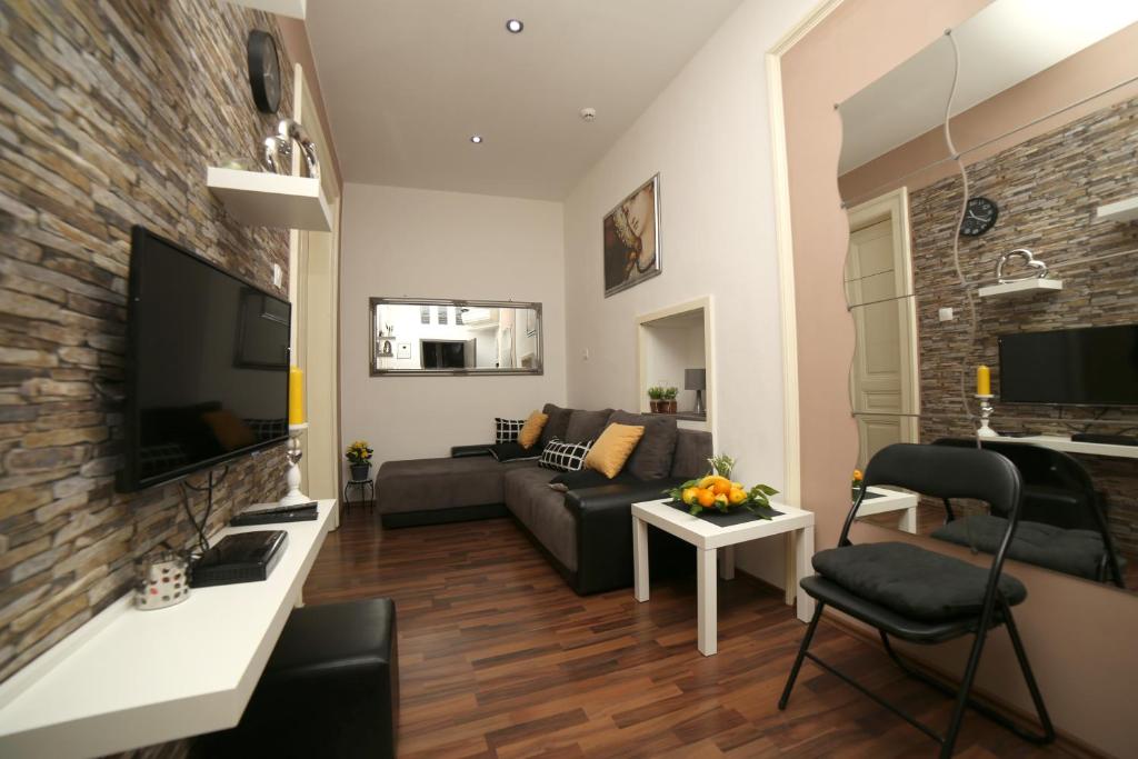 a living room with a couch and a tv at SubCastrum Apartments in Pula