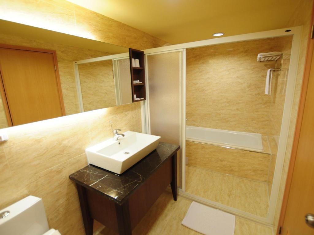 a bathroom with a sink and a shower at Kindness Hotel - Tainan Chihkan Tower in Tainan