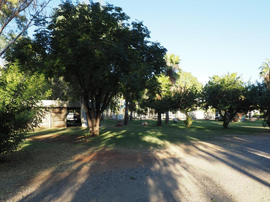 a dirt road with trees on the side of a street at Heritage Caravan Park in Alice Springs