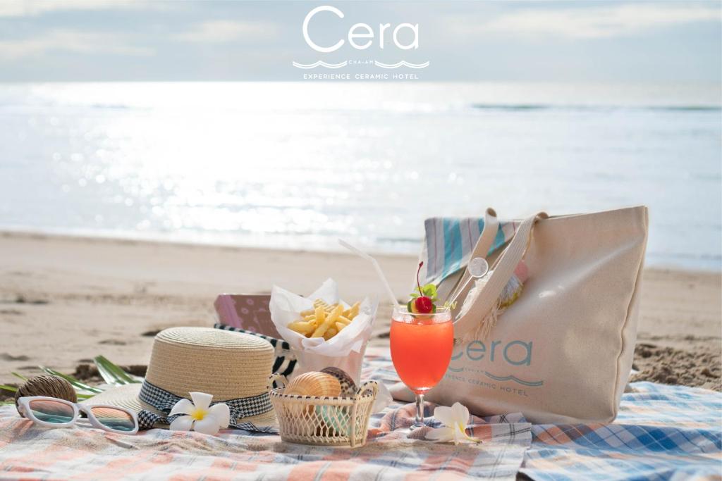 un picnic en la playa con una bolsa y una bebida en Cera Resort @ Cha-am, en Cha Am