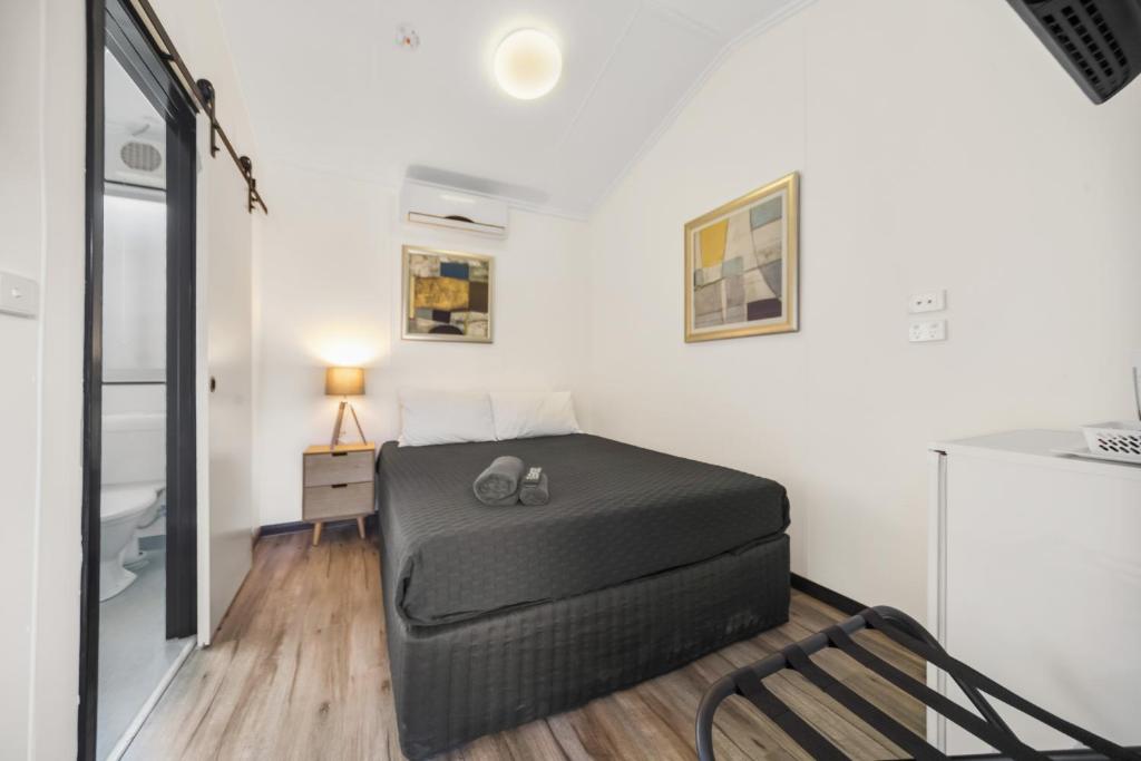a bedroom with a bed and a chair in a room at Latitude20 Roebourne Village in Roebourne