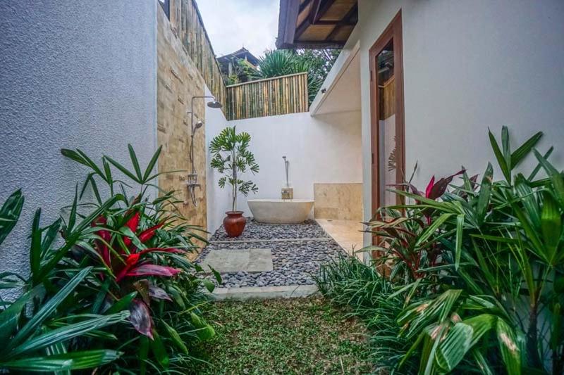 a bathroom with a tub and some plants at Dusun Ubud in Ubud