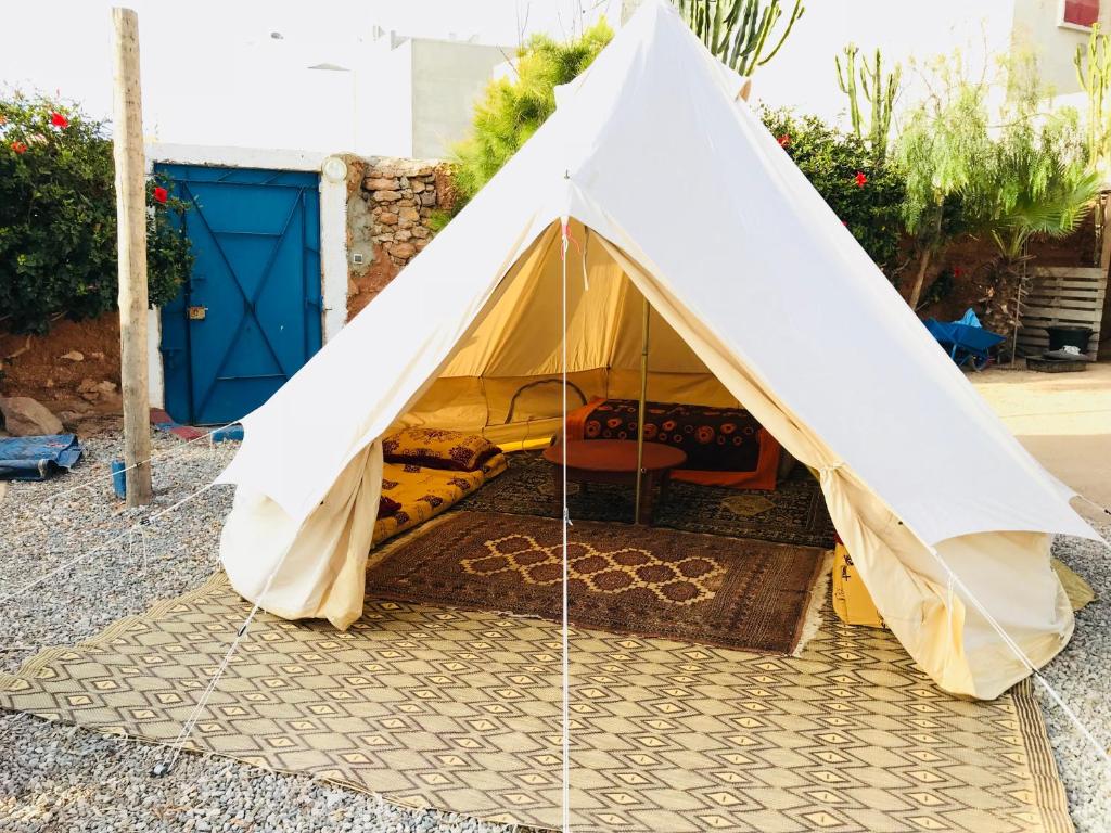 a tent in a courtyard with a blue door at Gite Le Nomade in Mirleft