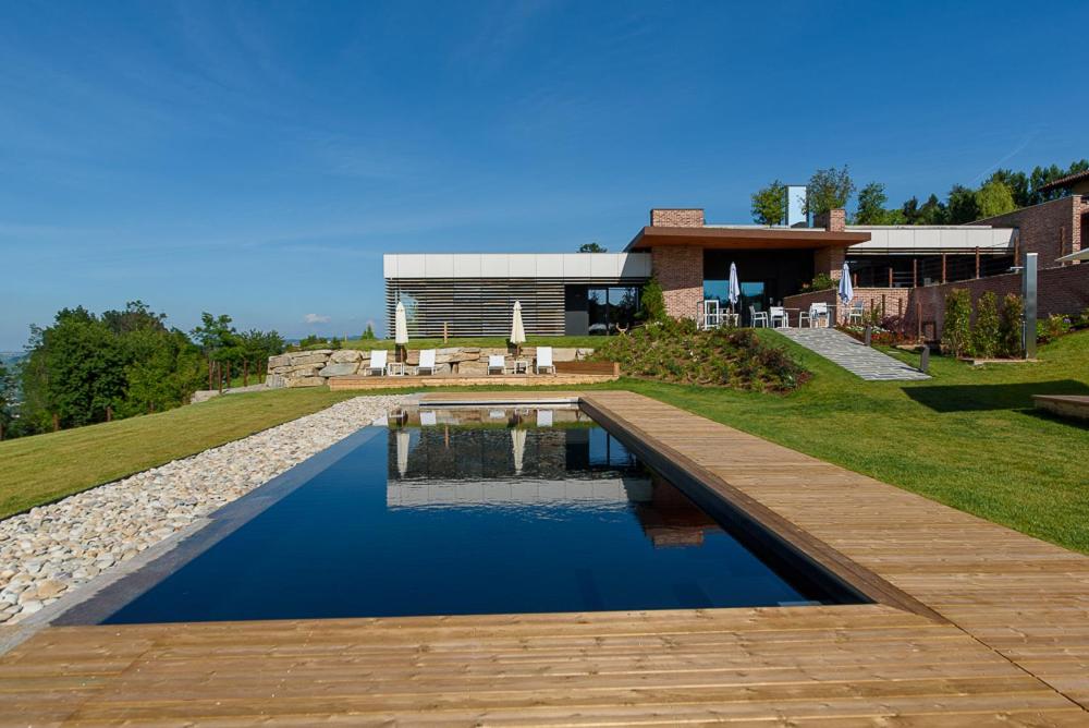 una casa con piscina di fronte a una casa di Relais Le Rocche a La Morra