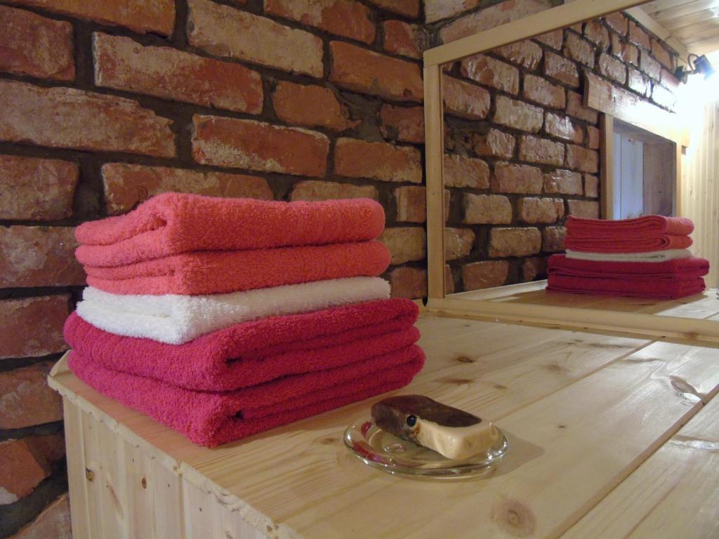 a stack of towels sitting on a table in front of a mirror at Žilių sodyba in Plateliai