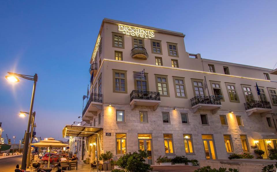 een groot wit gebouw met een bord erop bij Diogenis Hotel in Ermoupoli