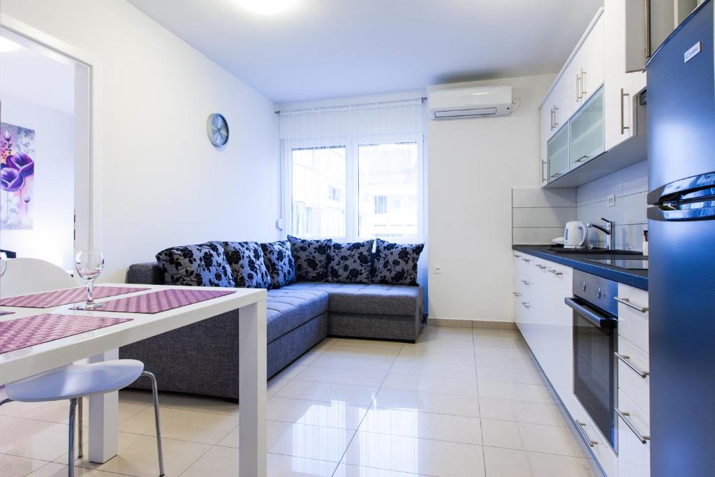 a kitchen and a living room with a couch at Apartments Kalelarga in Zadar