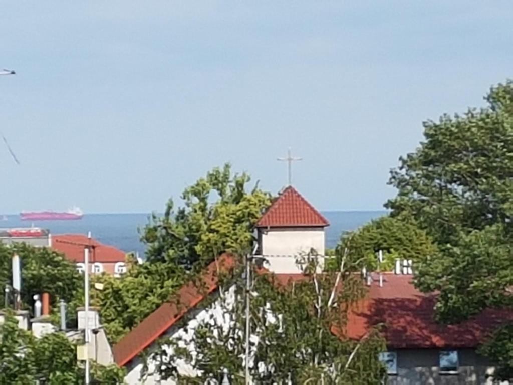 uma igreja branca com uma cruz no telhado em Wrzos em Sopot