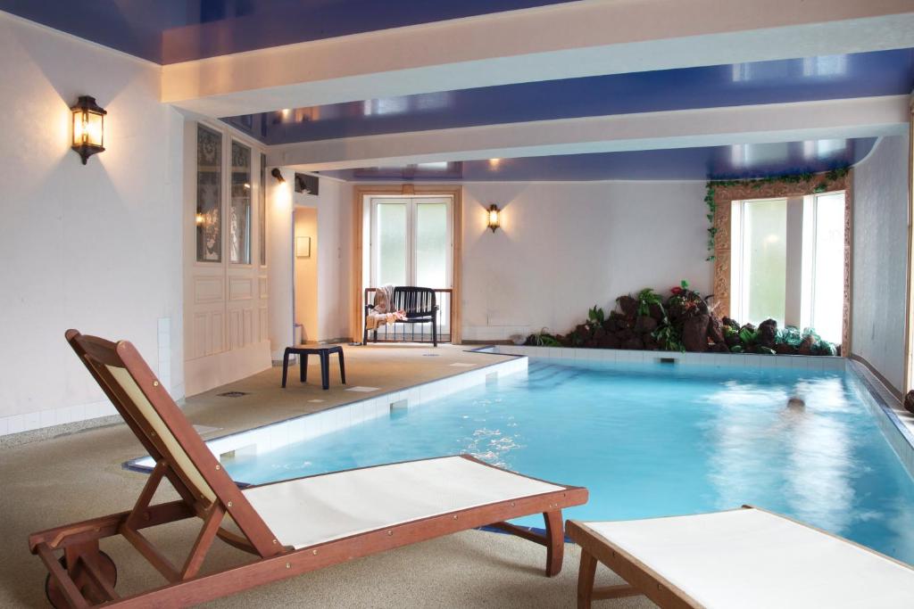 a large swimming pool with a chair at Hôtel de l'Aviation in La Bourboule