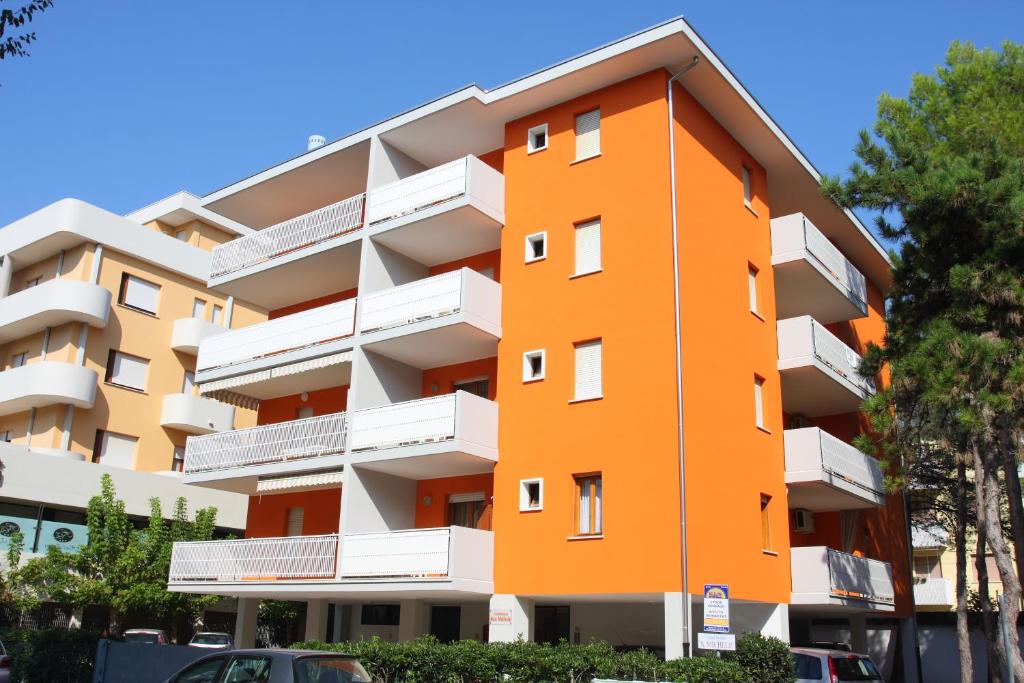 un immeuble orange avec des balcons blancs dans l'établissement Condominio San Michele, à Bibione