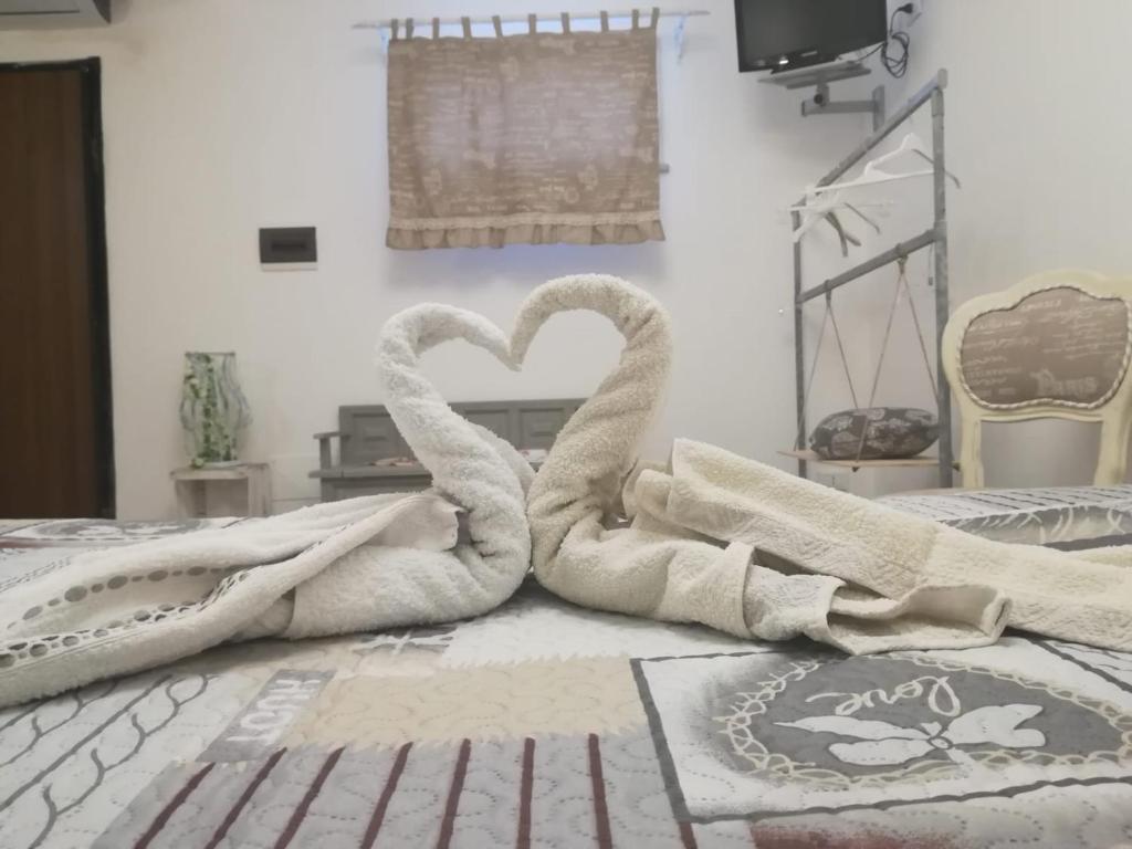 2 asciugamani cigni seduti sul pavimento di una camera da letto di Villa Eco-Chic a Carini
