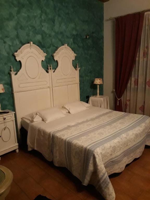 - une chambre avec un grand lit et une grande tête de lit dans l'établissement La Tenuta dell 'Orta, à Bolognano