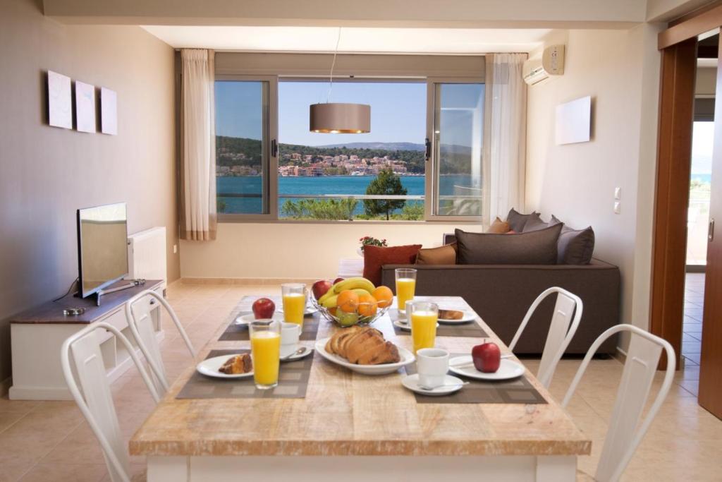 uma sala de jantar com uma mesa com comida e sumo de laranja em Gliving365 Capital em Argostoli