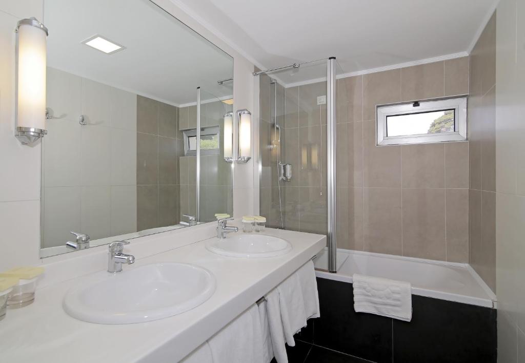 a bathroom with two sinks and a large mirror at Hotel Lero in Dubrovnik