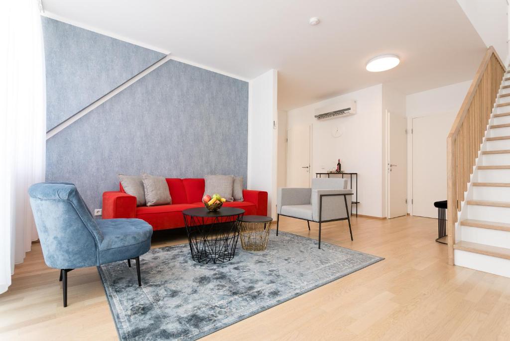 sala de estar con sofá rojo y silla azul en Mar Suite Apartments - Center, en Viena