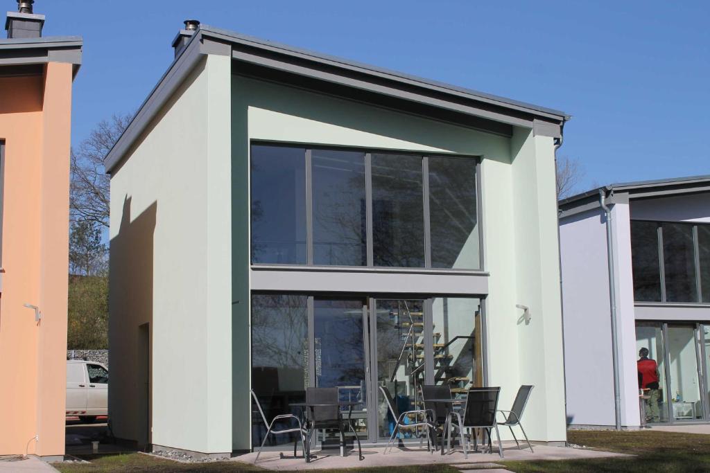 a house with glass doors and tables and chairs at Ferienpark Kunterbunt in Krakow am See