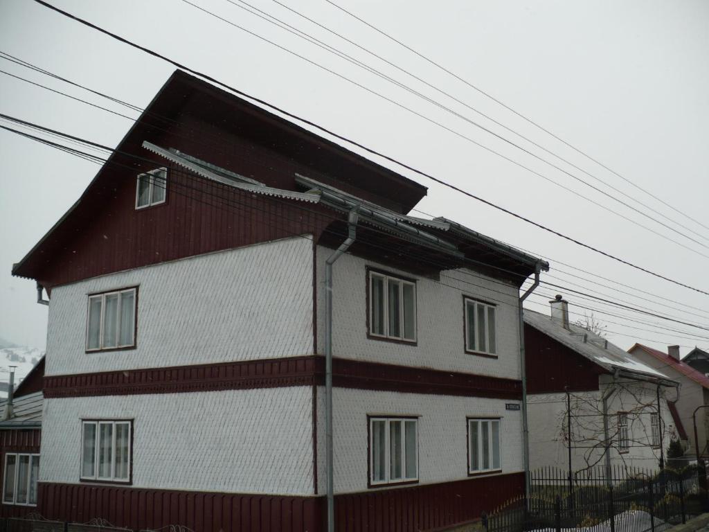 una casa de color rojo y blanco en Pensiunea Casa Rodica, en Gura Humorului