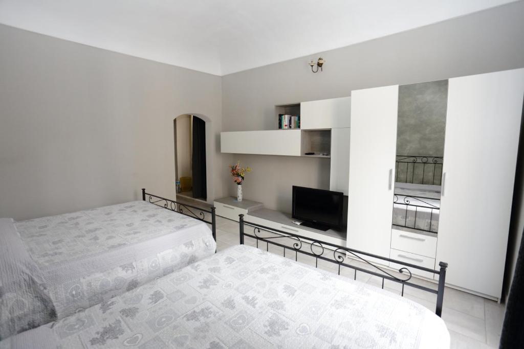 1 dormitorio con 2 camas y TV de pantalla plana en B&B L'Antico Portico, en Sorso