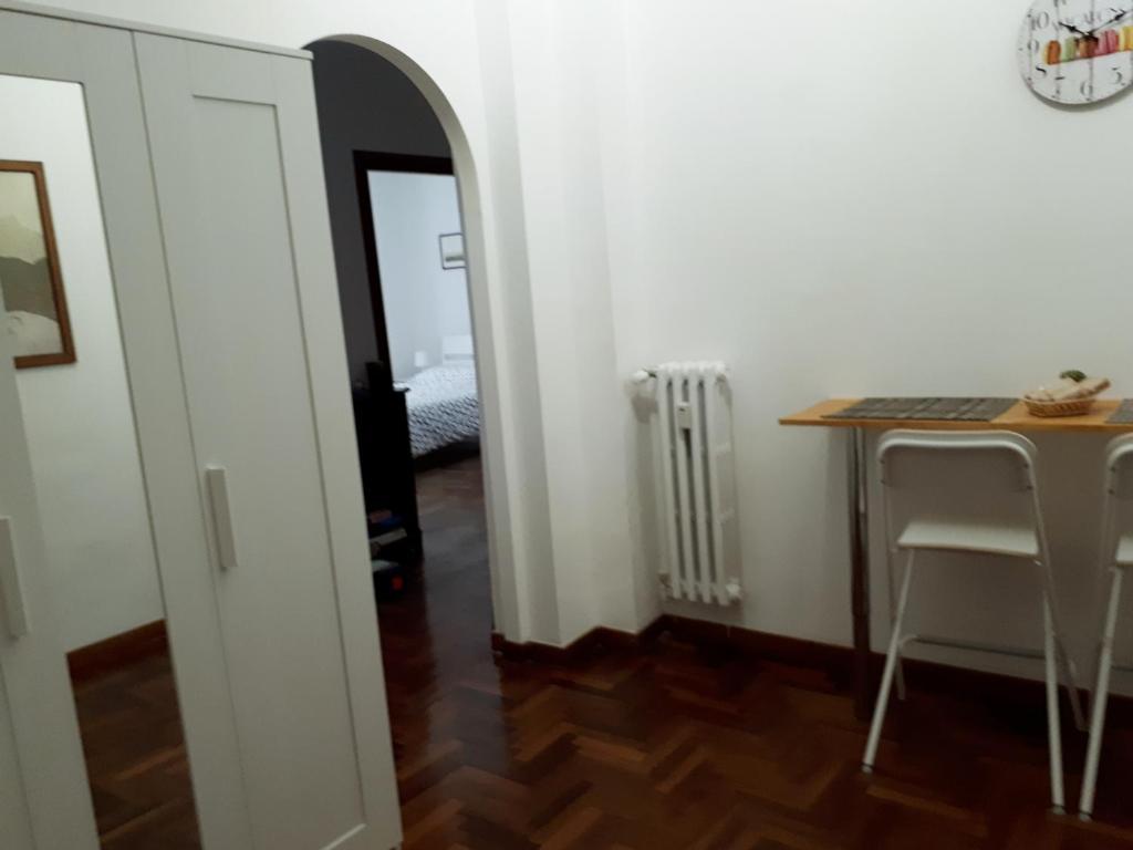 een kamer met een tafel, een bureau en een spiegel bij A casa di Robi in Rome