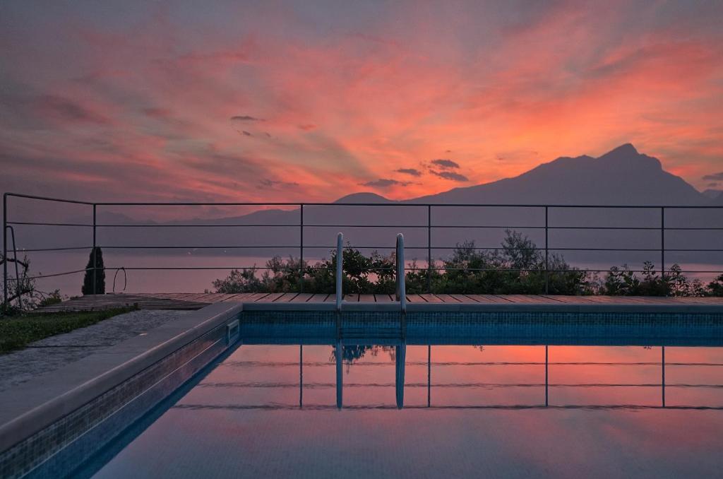 トッリ・デル・ベーナコにあるVilla Paolaの夕日を背景に見えるスイミングプール