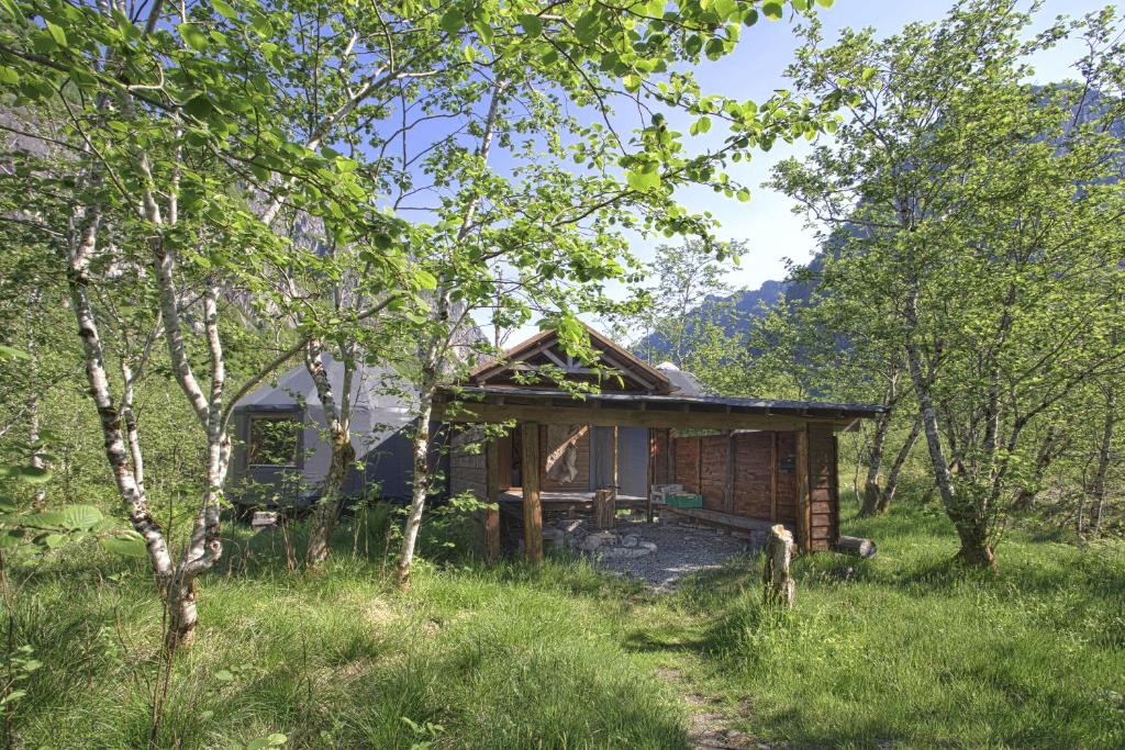 uma pequena cabana de madeira no meio de um campo em Hardanger Basecamp em Osa i Hardanger