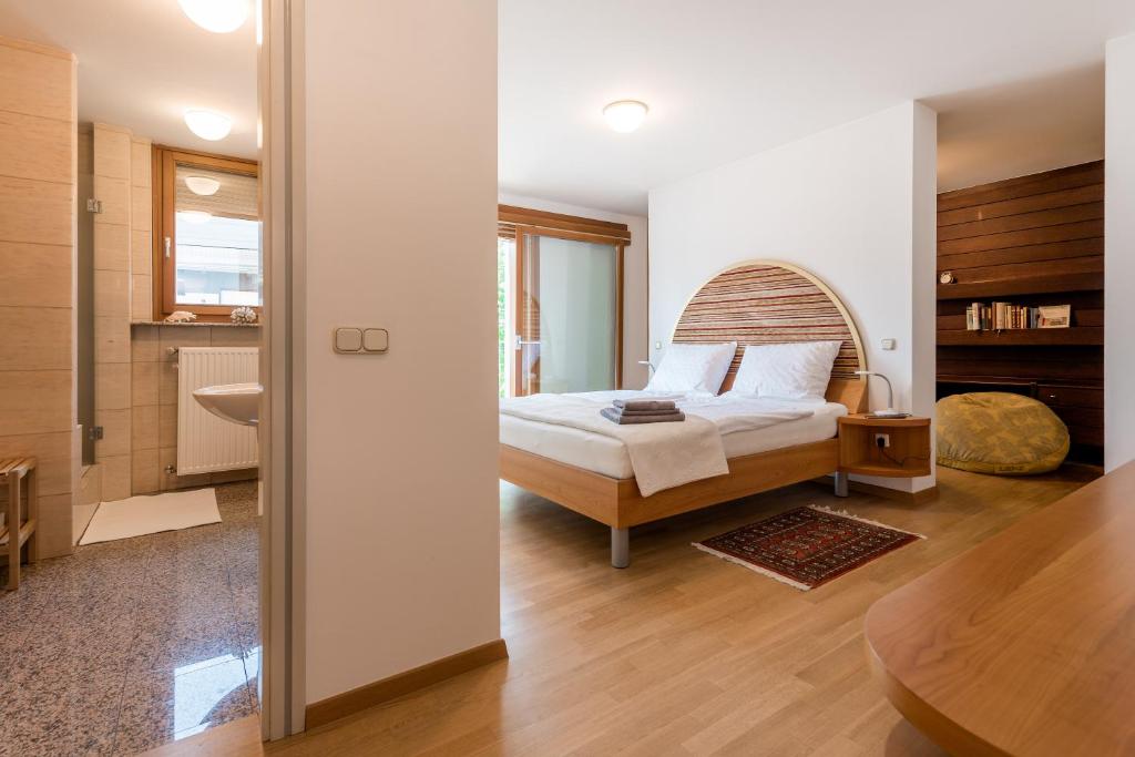 a bedroom with a bed with a wooden headboard at Rožna Dolina Apartment in Ljubljana