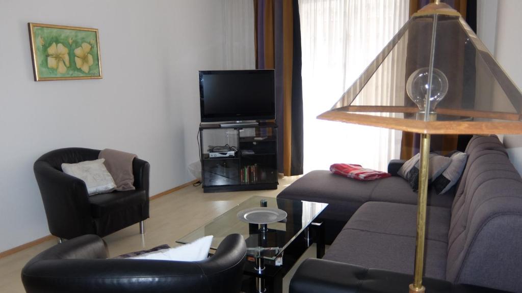 sala de estar con sofá, sillas y TV en Village Appartements, en Waidhofen an der Thaya