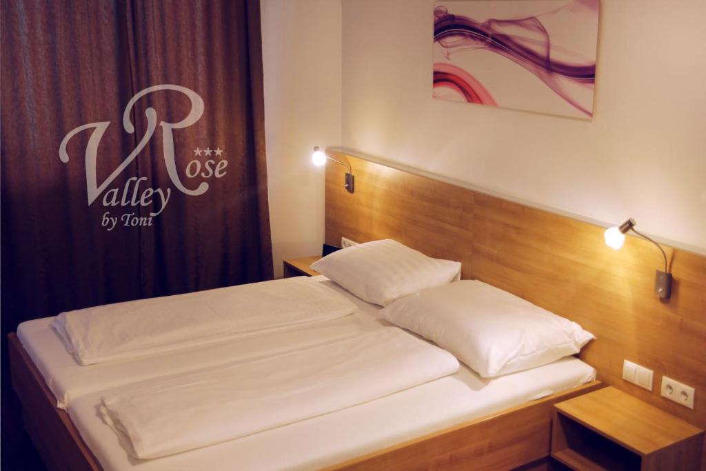 1 dormitorio con 1 cama con cabecero de madera en Hotel - Restaurant Valley Rose en Viena