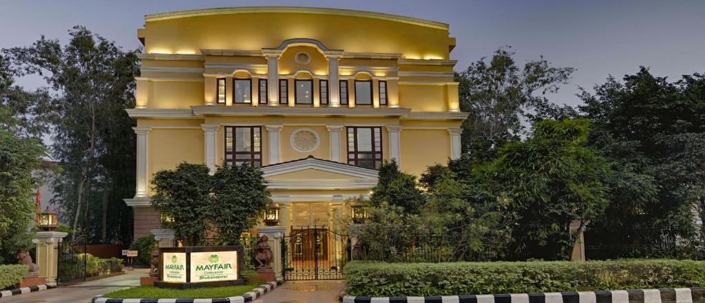 a large yellow building with a dome on top of it at Mayfair Convention in Bhubaneshwar