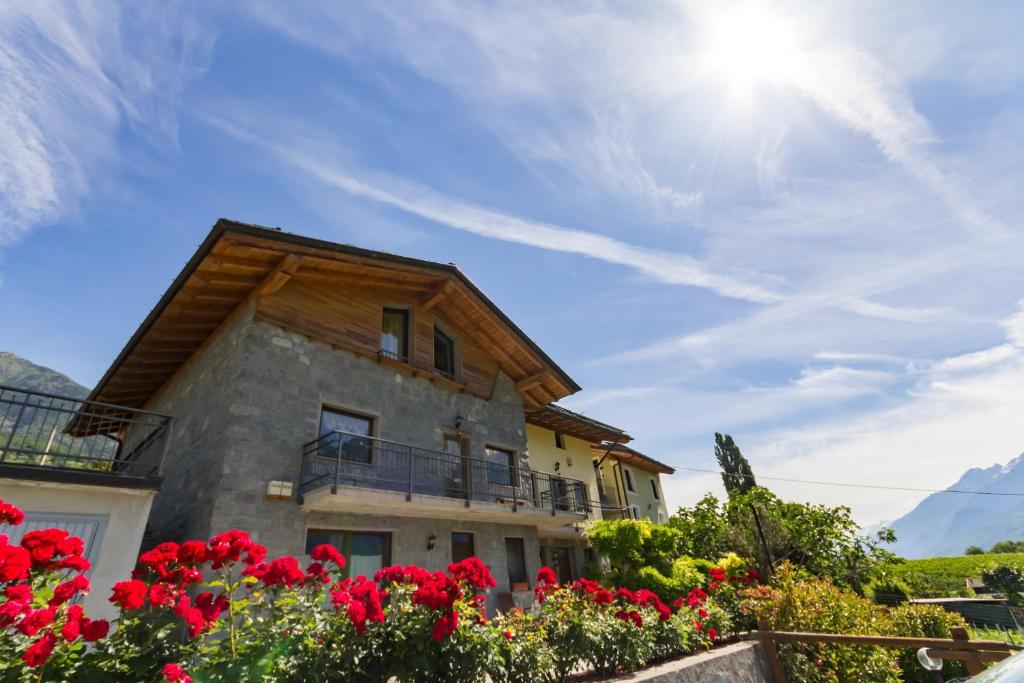 ein Haus mit roten Blumen davor in der Unterkunft Vistarelax in Aosta