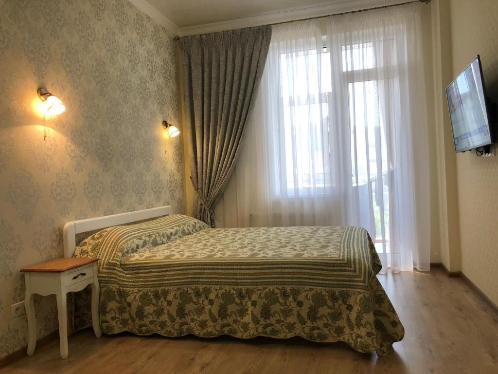 sypialnia z łóżkiem przed oknem w obiekcie Morskaya zhemchuzhina na Marselskoy w mieście Kryżanowka