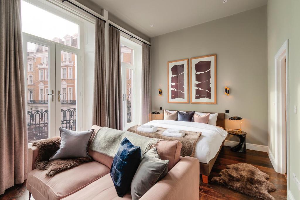 um quarto com uma cama, um sofá e uma janela em The Knaresborough by Aura Collection em Londres