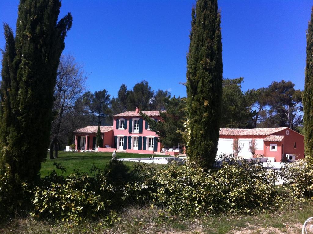 a pink house with trees in the foreground at Putt Tee Country in Nans-les-Pins